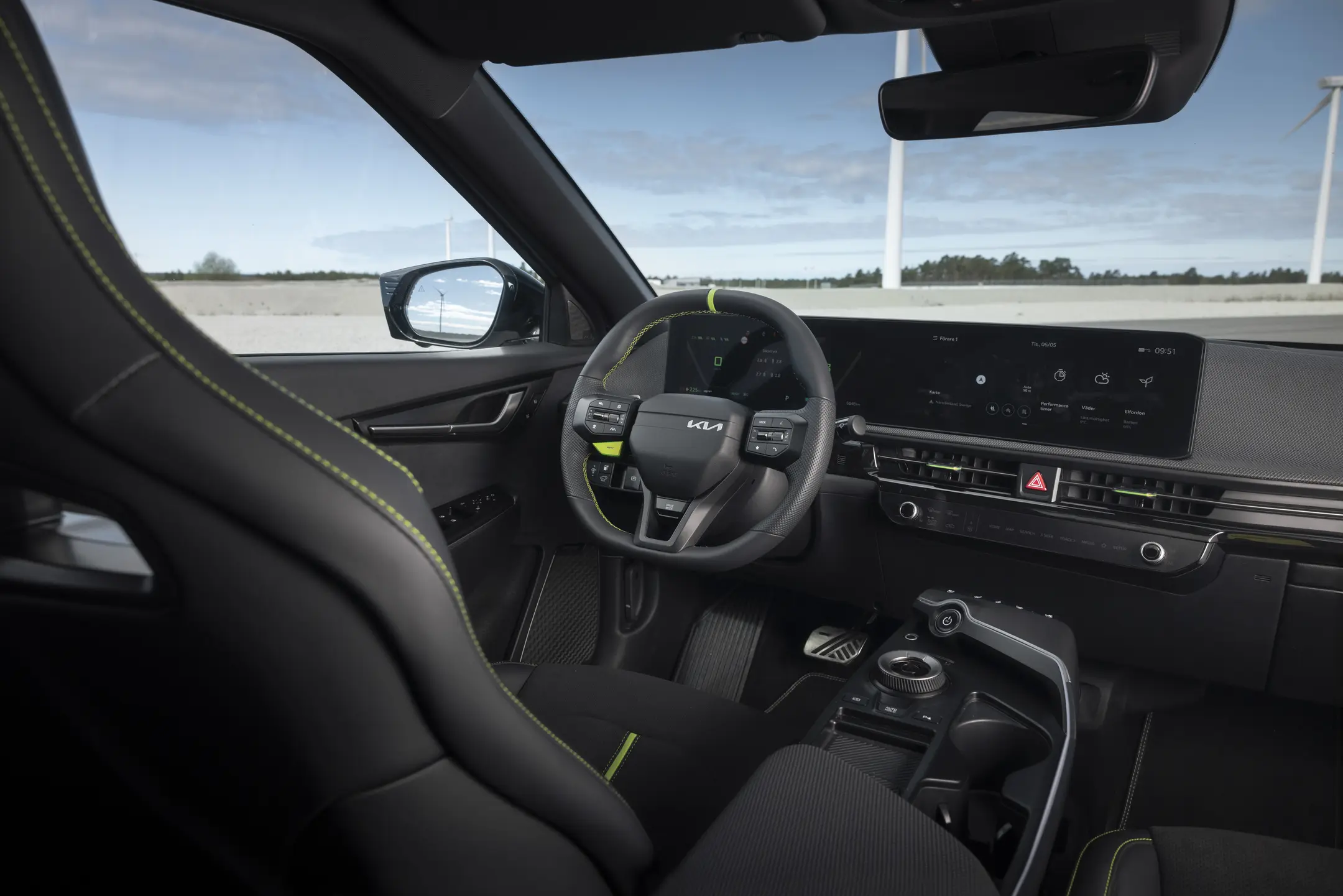 Närbild på ratten och instrumentpanelen i en Kia EV6 GT, med detaljer som växlingspaddlar och digitala skärmar.