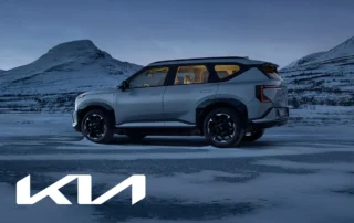 Kia EV5 elektrisk SUV i silver på snötäckt mark med vinterlandskap och fjäll i bakgrunden