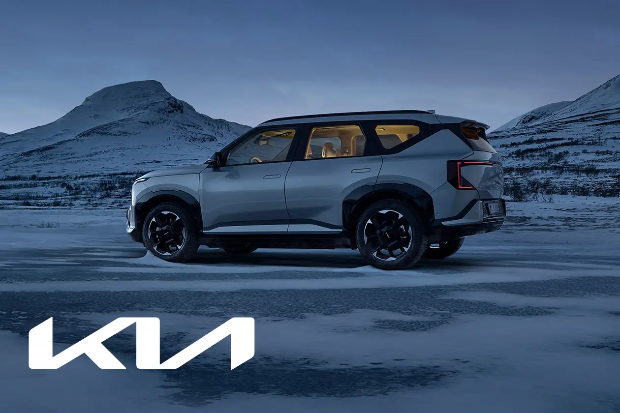 Kia EV5 elektrisk SUV i silver på snötäckt mark med vinterlandskap och fjäll i bakgrunden