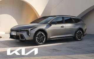 Kia K4 Sportswagon i grå metallicfärg parkerad framför modern arkitektur