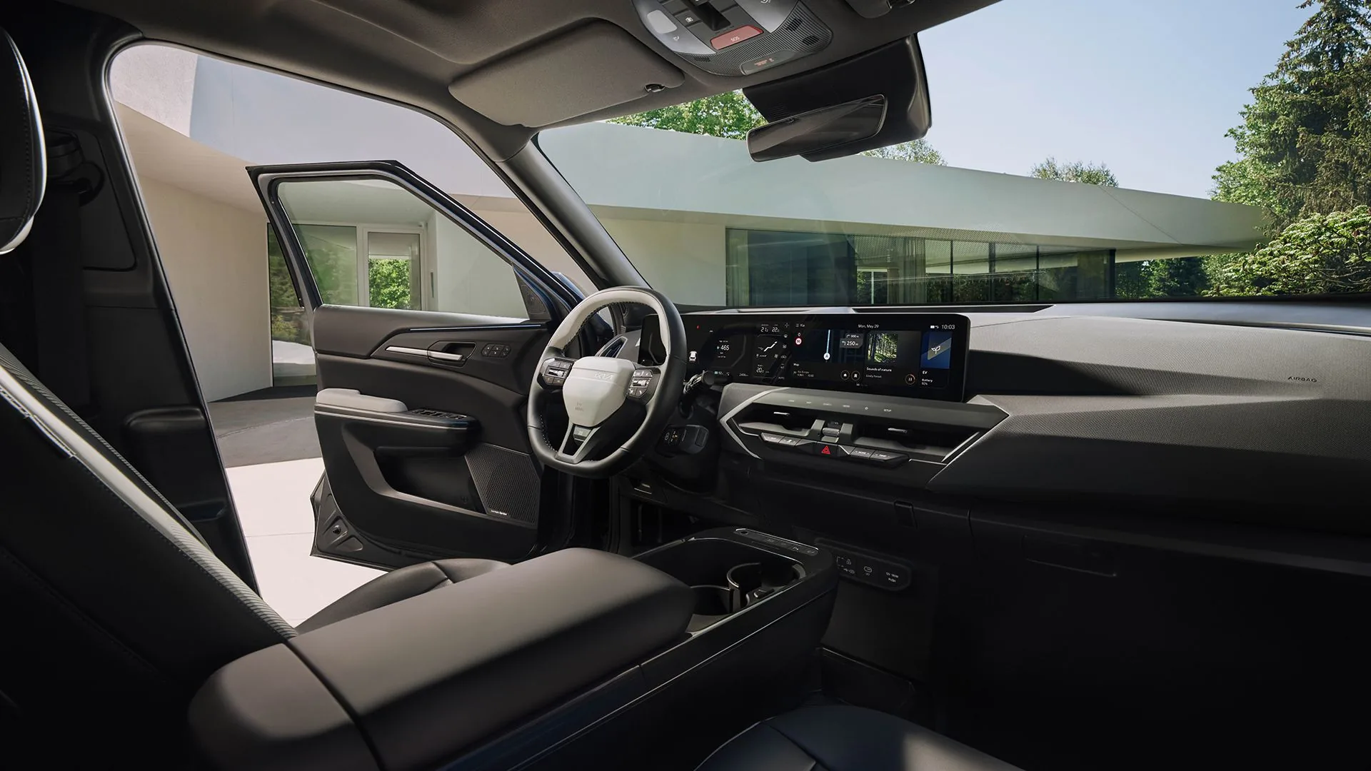 Förarplatsen i Kia EV5 med de breda panoramaskärmarna hos Bylunds Bil i Karlshamn