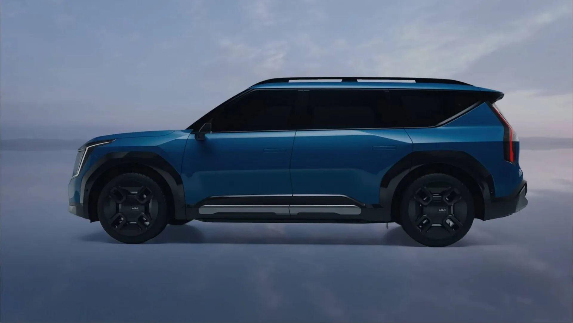 Blå Kia EV9 i profil mot en ljus himmel hos Bylunds Bil i Karlshamn