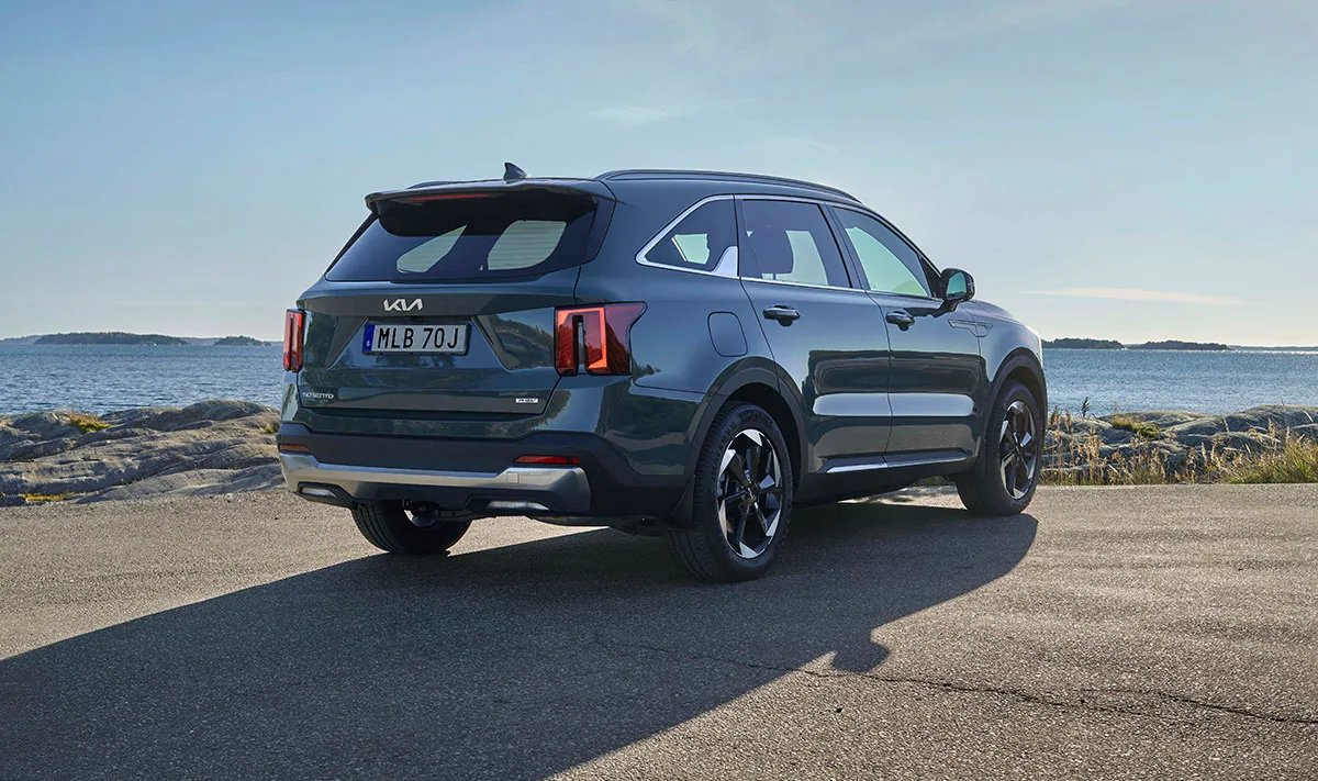 Kia Sorento Plug-in Hybrid bakifrån med originalhjul, parkerad vid havet