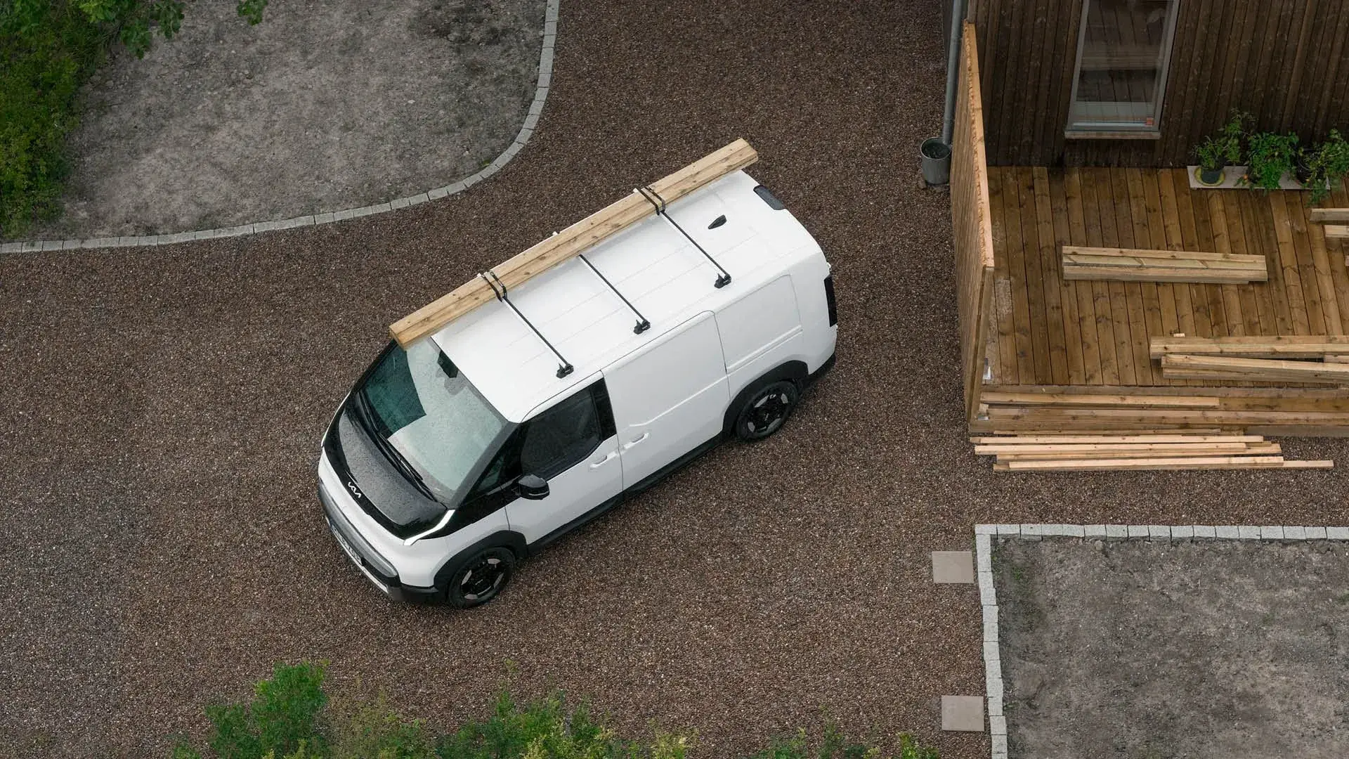 Kia PV5 Cargo ovanifrån med virke på taket hos Bylunds Bil i Karlshamn